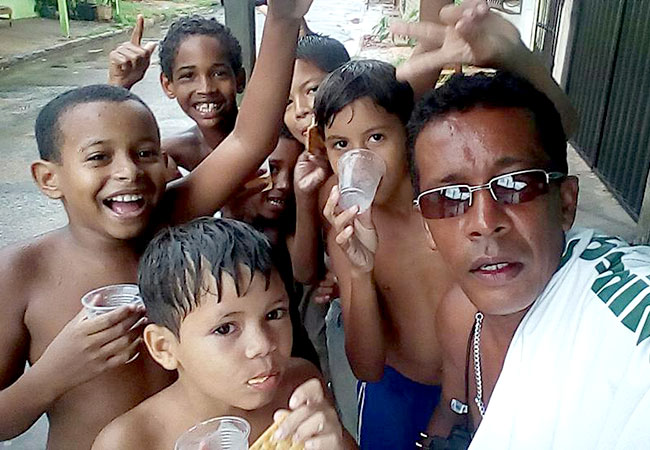 galeria-3 #PraCegoVer Self do voluntário José de Ribamar e as crianças que ele ajuda