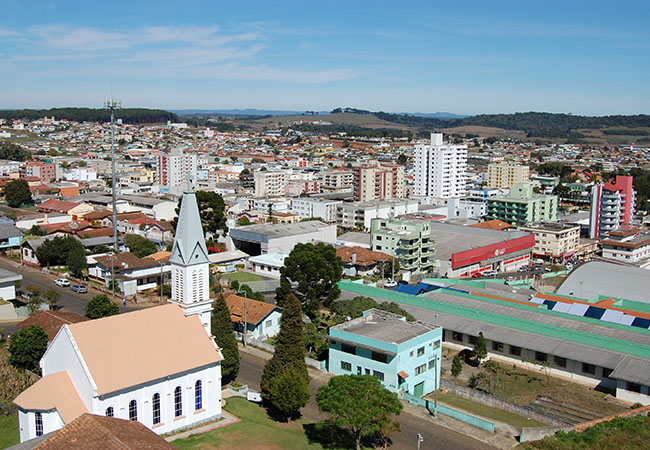 #PraCegoVer Imagem panorâmica da cidade de Curitibanos, em Santa Catarina, em um dia de sol